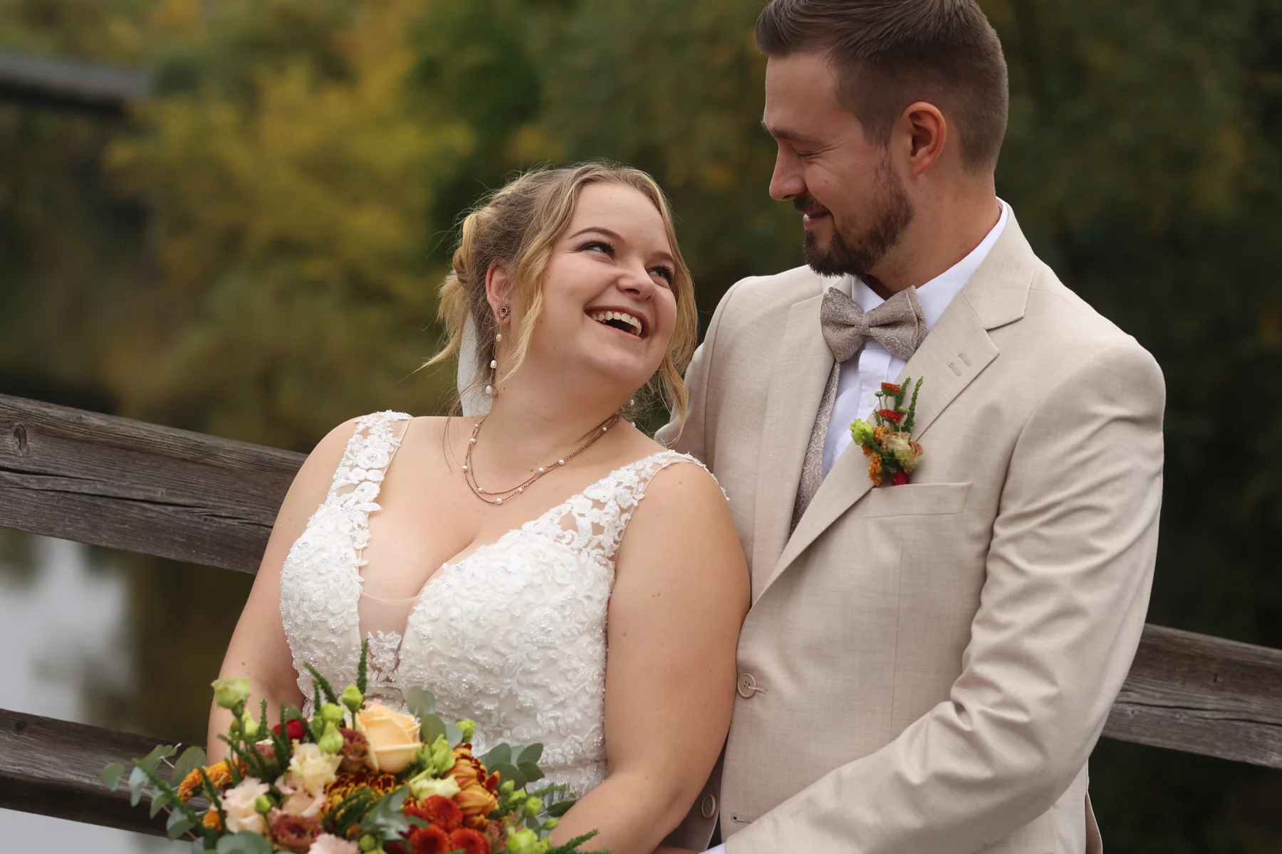 Jennifer und Tobias lachen einander im herbstlichen Grün an